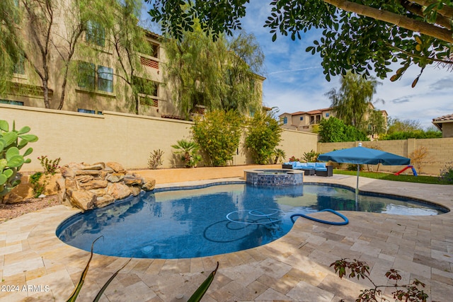 view of pool with a patio and an in ground hot tub