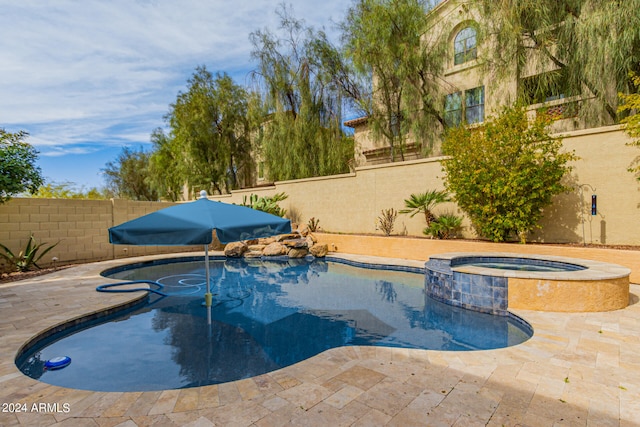 view of swimming pool featuring a patio area and an in ground hot tub