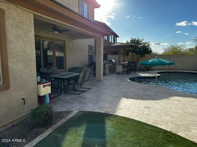 view of terrace with ceiling fan and a fenced in pool