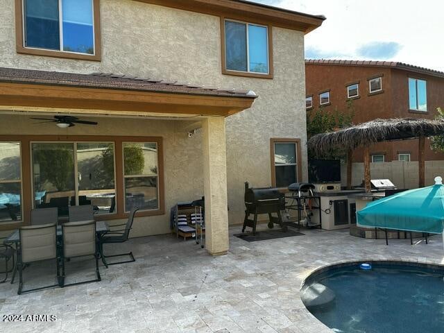 rear view of house featuring ceiling fan and a patio