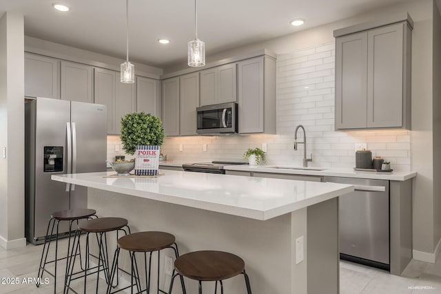 kitchen with a center island, appliances with stainless steel finishes, gray cabinets, and sink