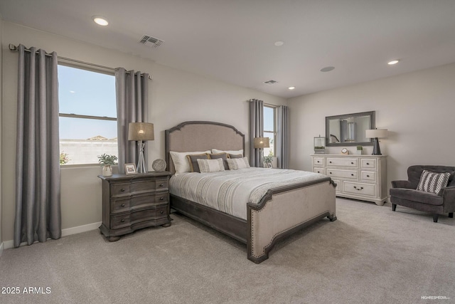 bedroom with light colored carpet, a water view, and multiple windows