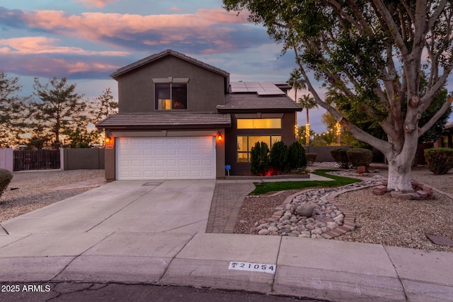 view of front of home featuring a garage and solar panels