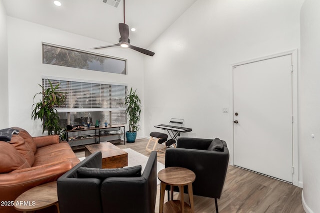 living room with ceiling fan, high vaulted ceiling, and light hardwood / wood-style floors