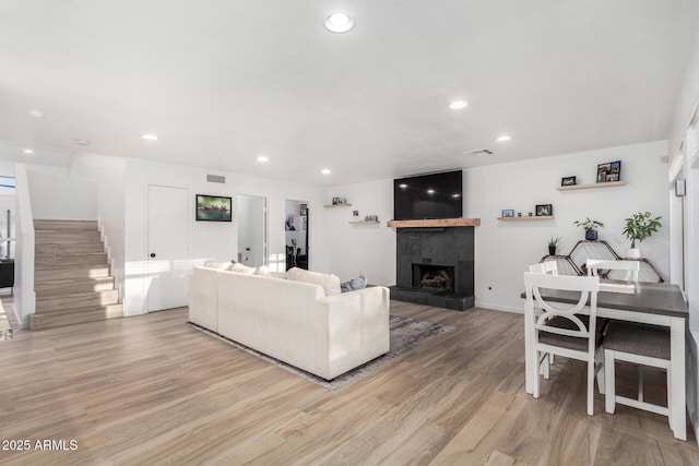 living room with a fireplace and light wood-type flooring