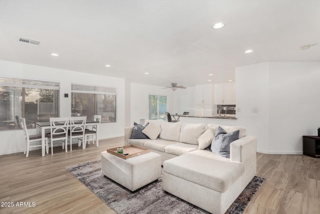 living room featuring ceiling fan and light hardwood / wood-style floors