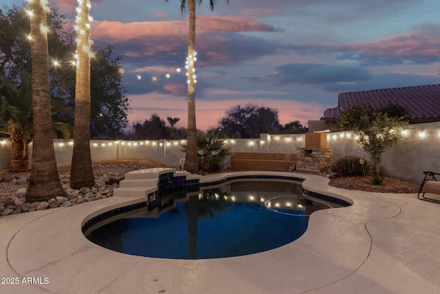 pool at dusk with a patio area