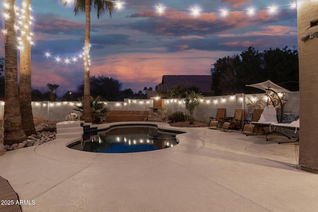 pool at dusk with a patio area