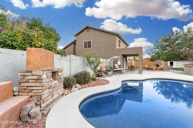 view of pool with area for grilling, a fireplace, and a patio area