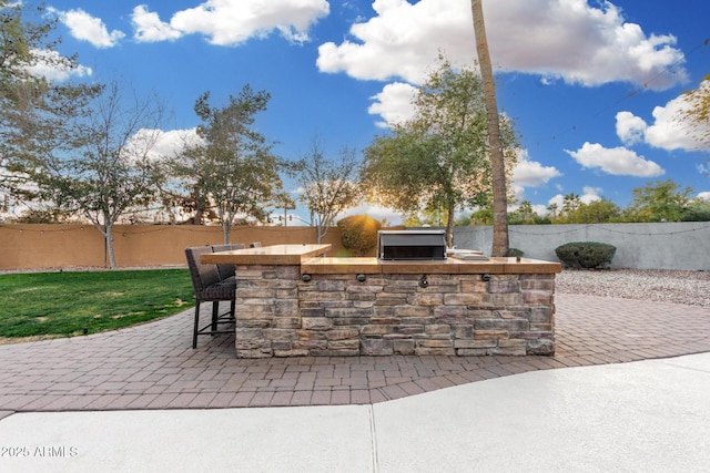 view of patio with area for grilling and an outdoor bar