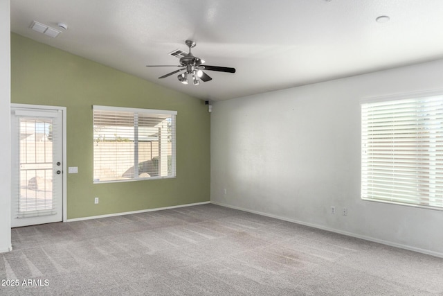 carpeted spare room featuring vaulted ceiling and ceiling fan