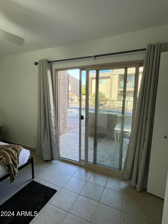 empty room with ceiling fan and light tile patterned flooring