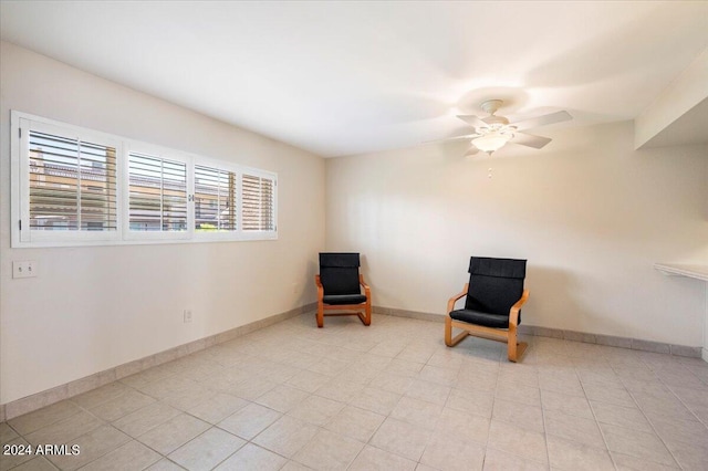 living area with ceiling fan and light tile patterned floors