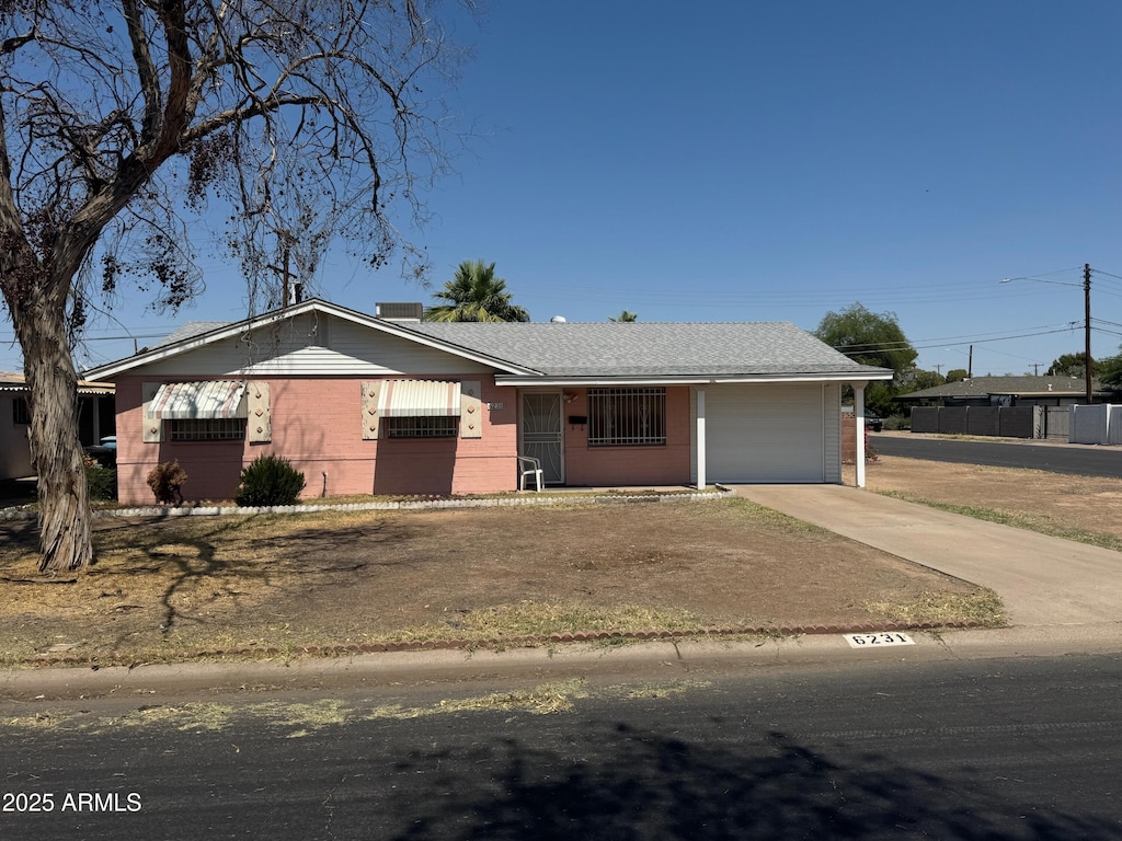 6231 N 25th Ave, Phoenix, AZ 85015 - ranch-style house featuring a garage, concrete driveway, and brick siding
