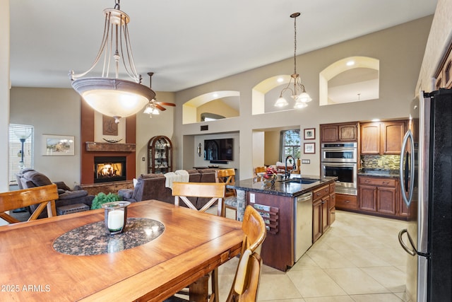 kitchen with a center island, sink, a fireplace, appliances with stainless steel finishes, and tasteful backsplash