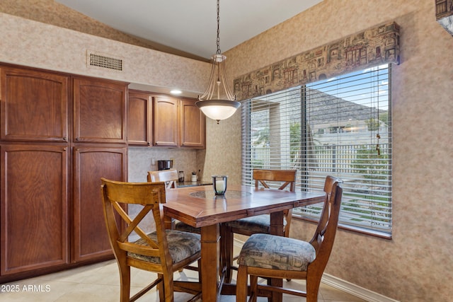 tiled dining area featuring lofted ceiling