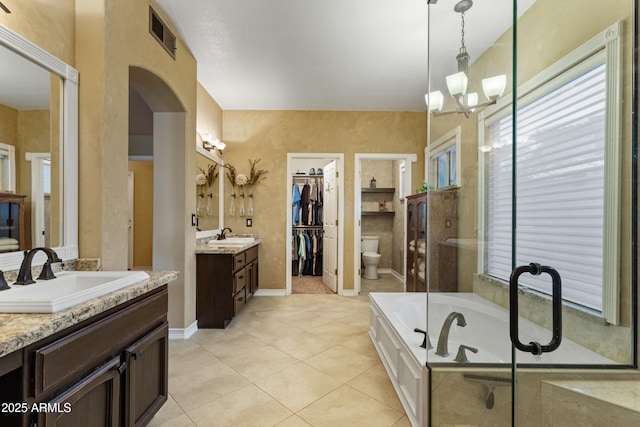 full bathroom featuring vanity, an inviting chandelier, independent shower and bath, tile patterned flooring, and toilet