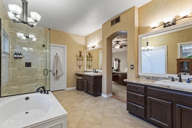 bathroom with tile patterned flooring, ceiling fan with notable chandelier, separate shower and tub, and vanity