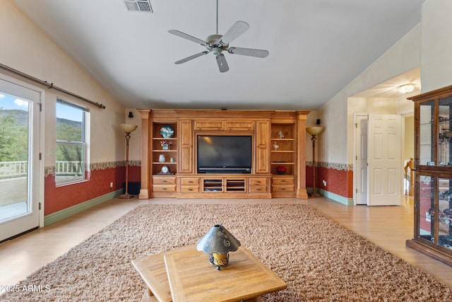 living room featuring ceiling fan, lofted ceiling, and light wood-type flooring