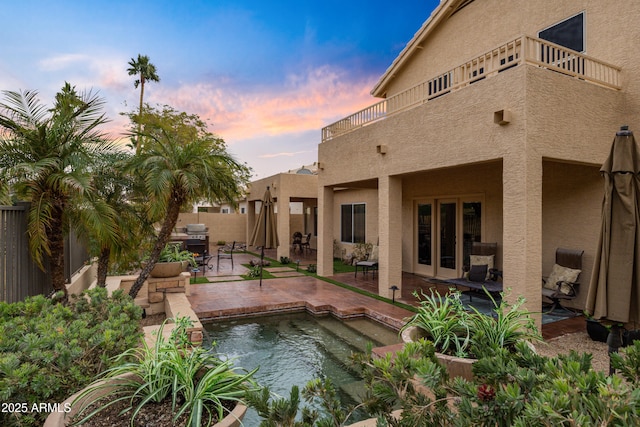 pool at dusk with a patio area