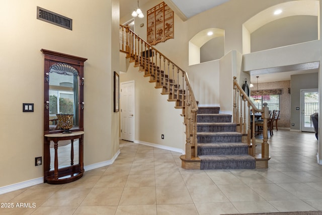 staircase with tile patterned flooring and a high ceiling