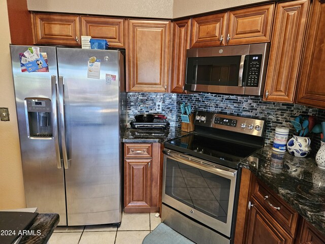 kitchen with stainless steel appliances, a textured ceiling, light tile patterned floors, sink, and a high ceiling