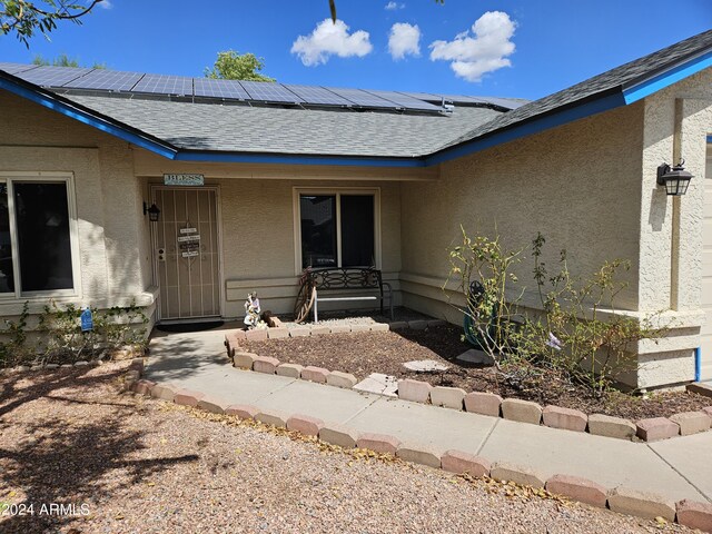 view of exterior entry with solar panels