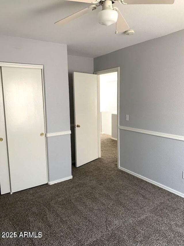 unfurnished bedroom featuring ceiling fan, a closet, and dark carpet