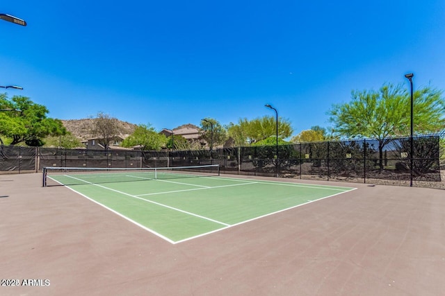 view of tennis court featuring basketball hoop