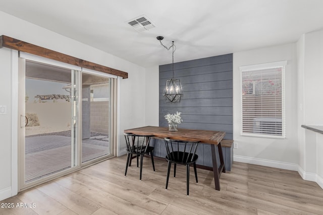 dining space featuring an inviting chandelier and light hardwood / wood-style flooring