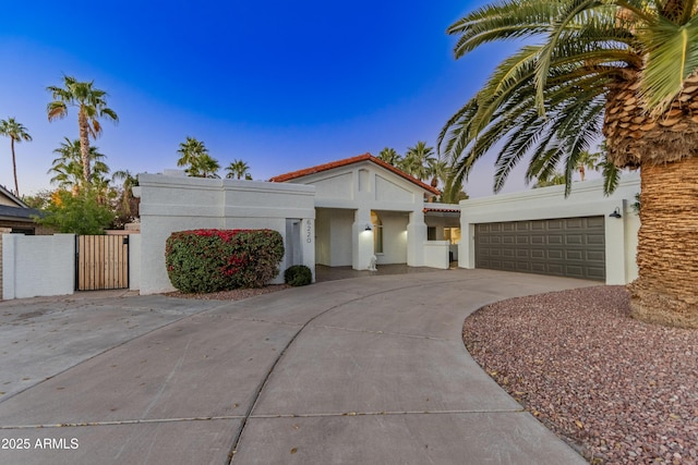 6220 E Paradise Ln, Scottsdale, AZ 85254 - mediterranean / spanish-style house with a gate, stucco siding, driveway, a tile roof, and a garage
