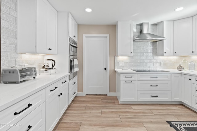 6220 E Paradise Ln, Scottsdale, AZ 85254 - kitchen with wall chimney exhaust hood, tasteful backsplash, white cabinets, recessed lighting, and light wood finished floors
