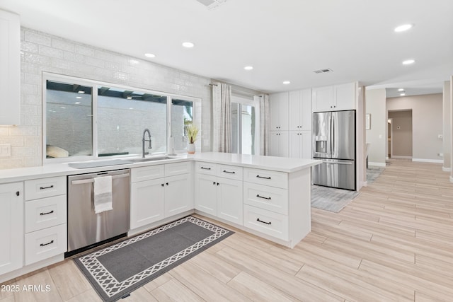 6220 E Paradise Ln, Scottsdale, AZ 85254 - kitchen with appliances with stainless steel finishes, a sink, a peninsula, white cabinets, and light countertops