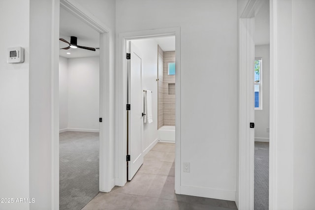 hallway featuring light colored carpet