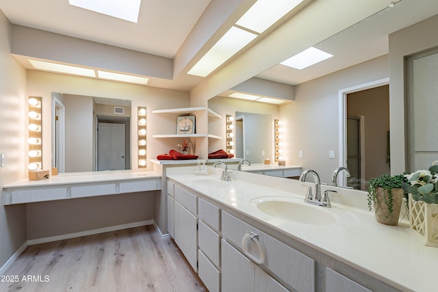 bathroom featuring hardwood / wood-style flooring, vanity, and a skylight