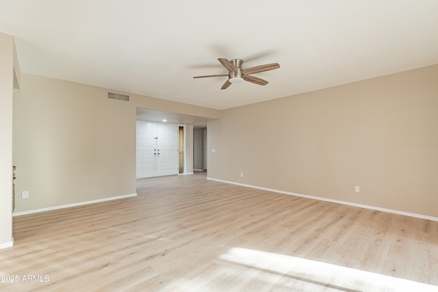 empty room with ceiling fan and light hardwood / wood-style flooring