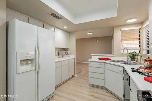 kitchen with white cabinetry, stainless steel dishwasher, sink, and white fridge with ice dispenser