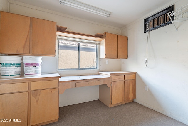 kitchen featuring built in desk and light carpet