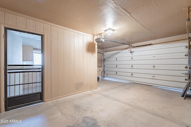 garage featuring a garage door opener and wood walls