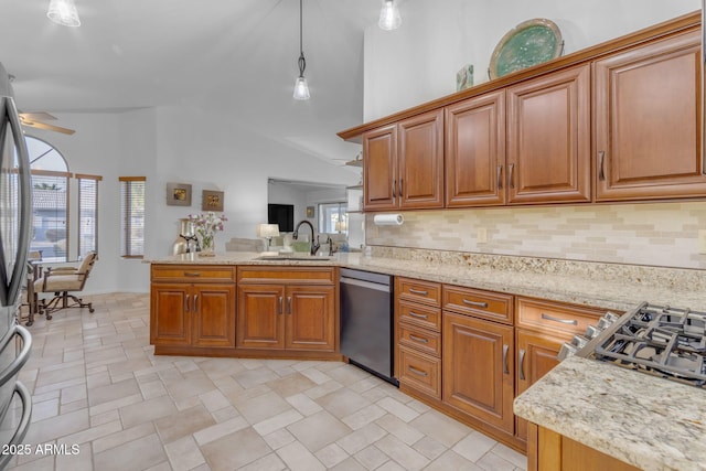 kitchen with appliances with stainless steel finishes, decorative light fixtures, tasteful backsplash, sink, and kitchen peninsula