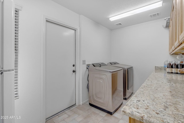 washroom featuring cabinets and washing machine and dryer