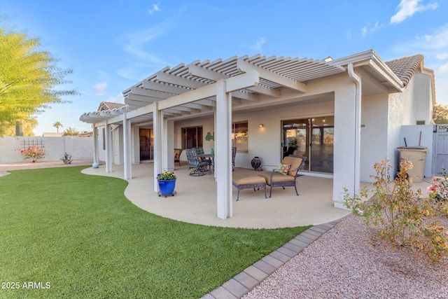 rear view of property featuring a yard, a pergola, and a patio