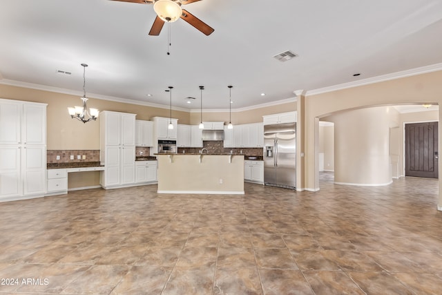 kitchen with white cabinets, stainless steel appliances, hanging light fixtures, and a kitchen island