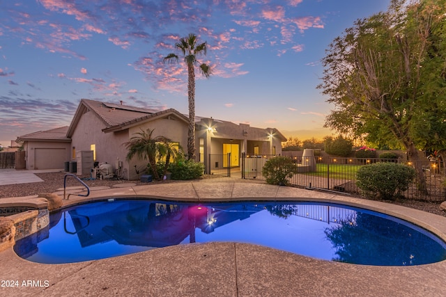 pool at dusk with a patio area