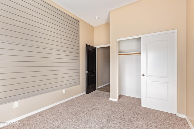 unfurnished bedroom featuring light carpet and a closet