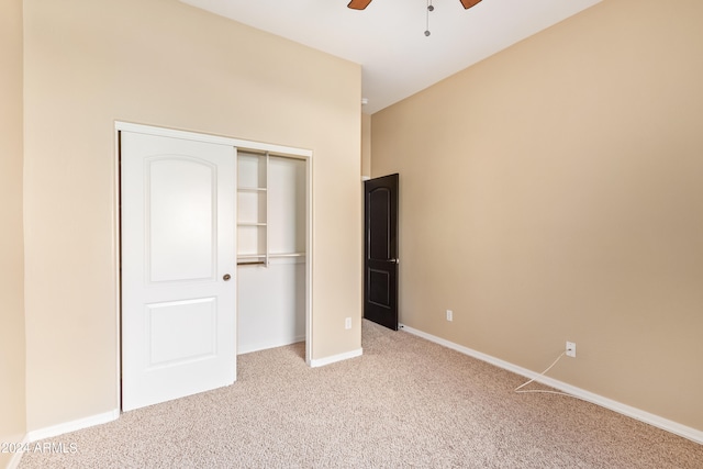 unfurnished bedroom with light carpet, a closet, and ceiling fan