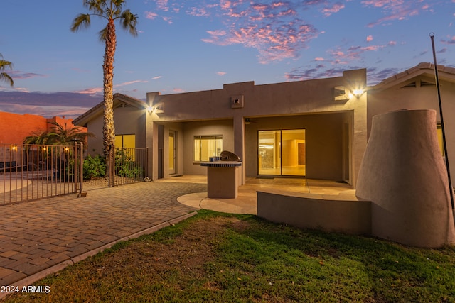 back house at dusk with a patio