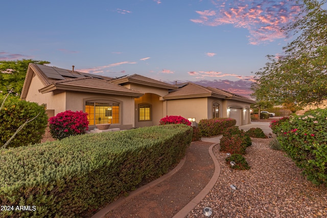 view of front of property with solar panels and a garage