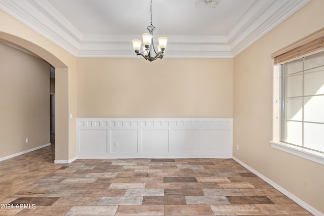 spare room with crown molding, a notable chandelier, and a tray ceiling