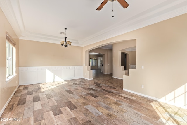 empty room featuring crown molding, hardwood / wood-style flooring, a raised ceiling, and ceiling fan with notable chandelier